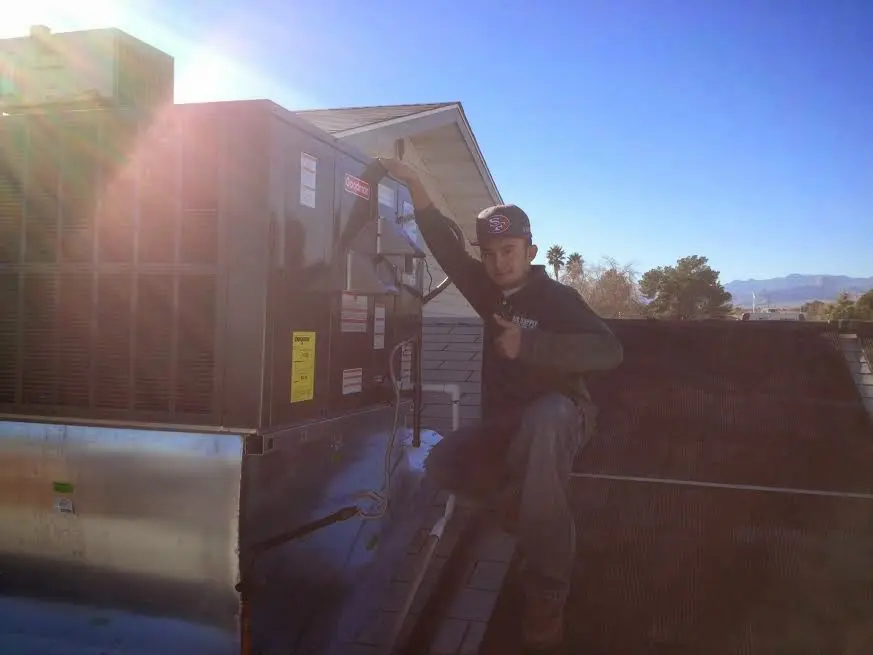 HVAC technician performing HVAC Inspection on a rooftop unit in Welby